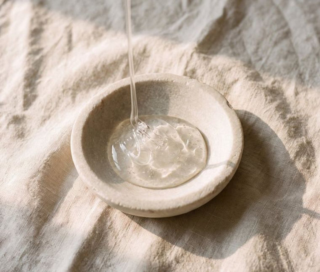 Clear gel in a stone dish, a strand lifting from the surface