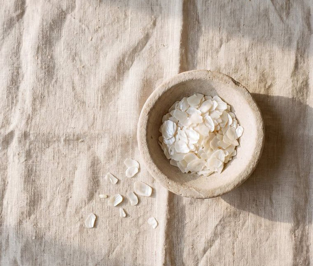 Pearlescent flakes in a stone dish on linen