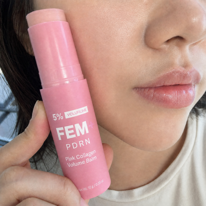 A woman at her desk pointing at the FEM+ PDRN stick