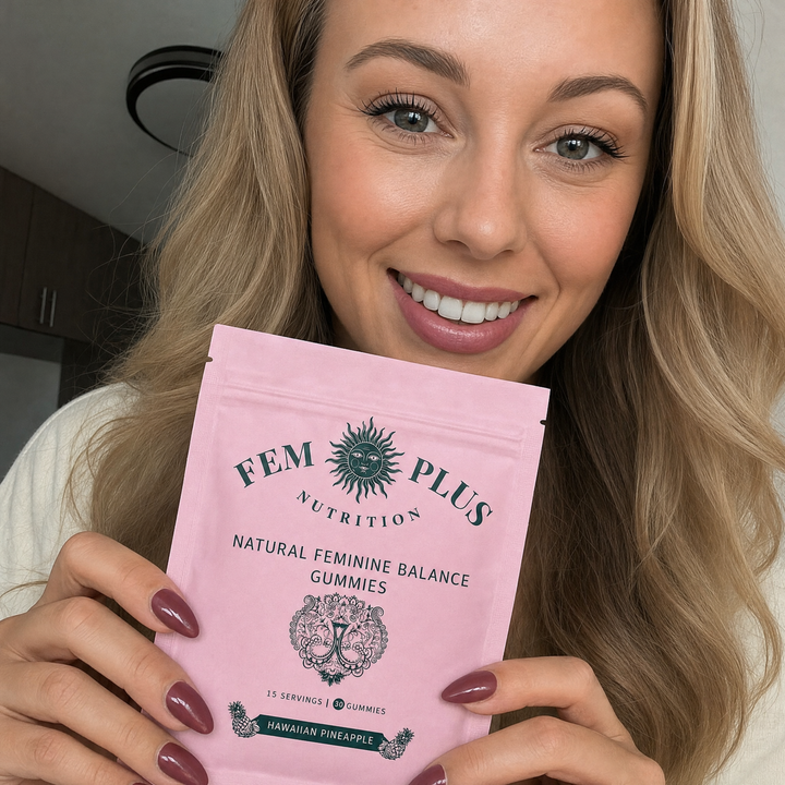 A blonde woman holding the FEM+ gummies pouch beside her face