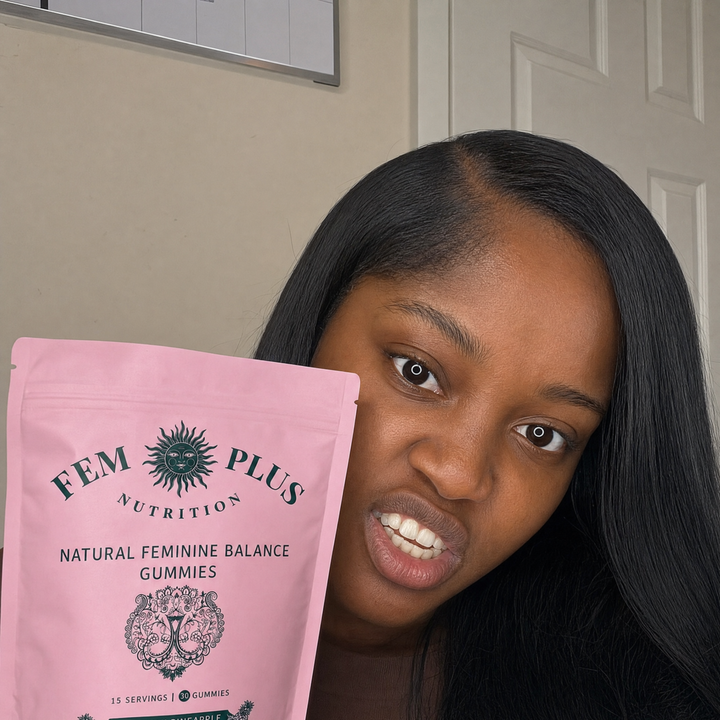 A woman leaning toward the camera with the FEM+ gummies pouch held out